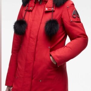 Bold red ski jacket with plush black fur accents. Snap off hood.